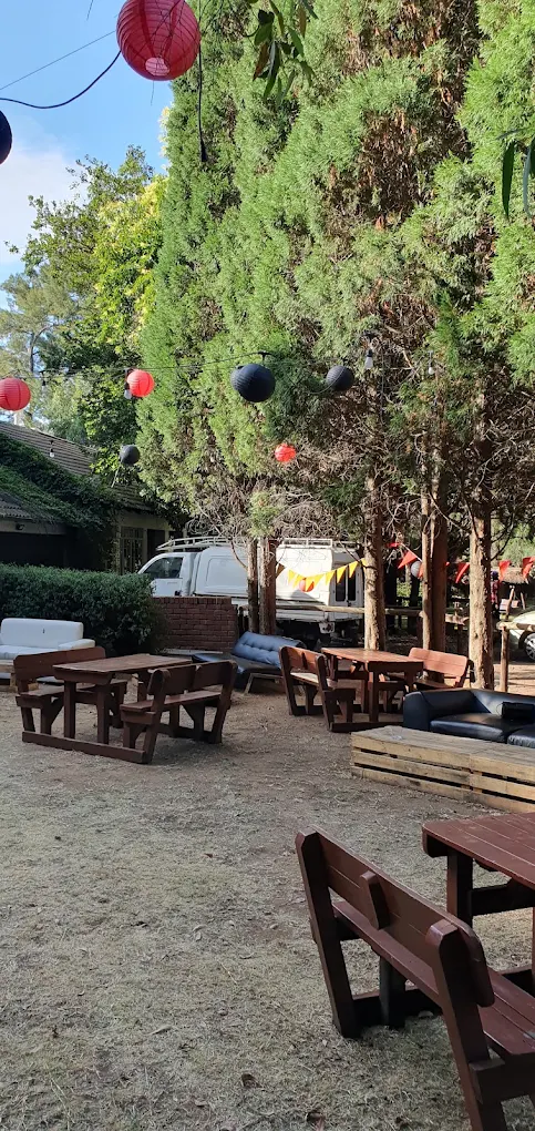 Outdoor seating under the trees at The Woods Pta